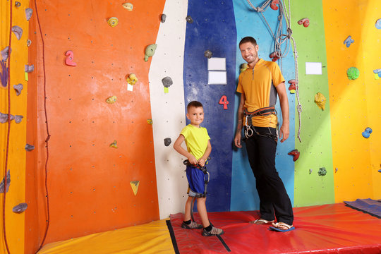 Little boy with trainer in climbing gym