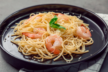 Plate of tasty pasta with shrimps on table, closeup