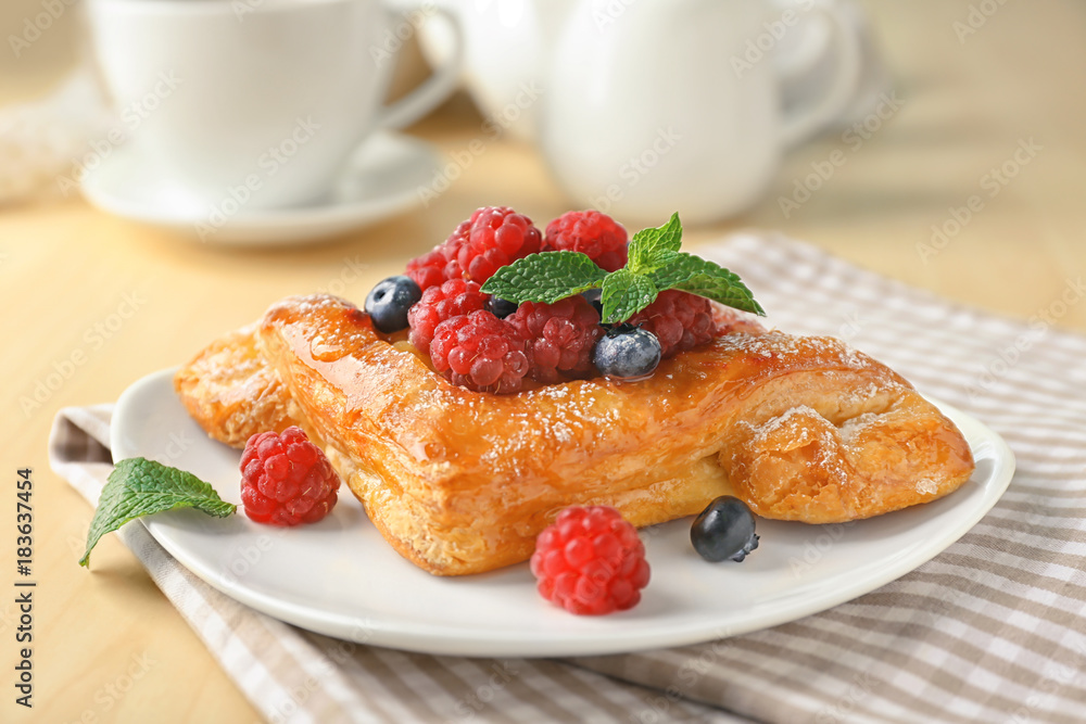 Sticker plate with yummy berry puff pastry on table