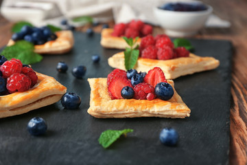 Yummy puff pastry with berries on slate plate