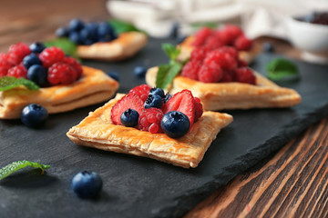 Yummy puff pastry with berries on slate plate