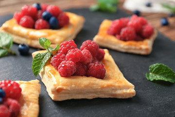 Plate with yummy berry puff pastry on wooden table