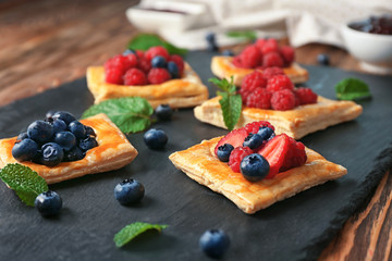 Yummy puff pastry with berries on slate plate