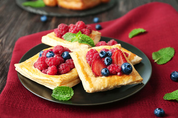 Plate with yummy berry puff pastry on table