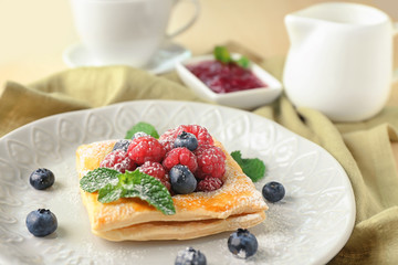 Plate with yummy berry puff pastry on table