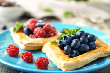Fototapeta premium Yummy puff pastry with berries on plate