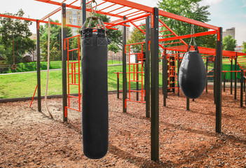 Punching bags for boxing on athletic field in park