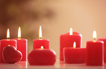 Burning red candles on table