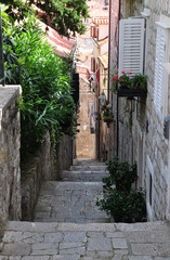 Fototapeta na wymiar old narrow street in Europe, lined with pavers, houses with facades in Croatia or Italy