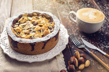 Homemade Christmas or New Year holiday chocolate pie with nuts on wooden table background. Concept of festive desserts