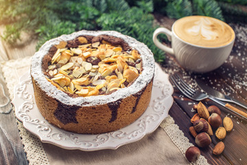 Homemade Christmas or New Year holiday chocolate pie with nuts on wooden table background. Concept of festive desserts