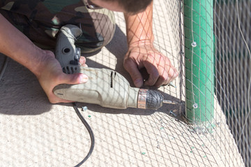 Worker twists the screw into the metal