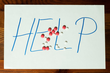 Suicidal note, Help sign letters written on paper with strong pain killer pills or tablets addiction or suicidal concept