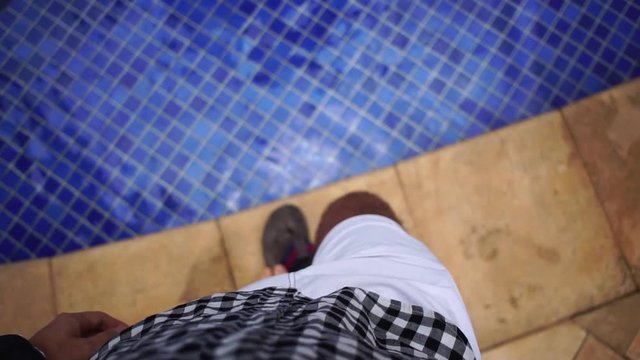 POV of a Man Walking on the Pool and Unbutton Shirt