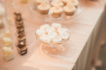 Fototapeta na wymiar Delicious and tasty dessert table with cupcakes shots at reception closeup