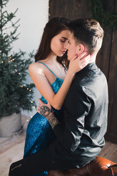 Beautiful romantic couple in love kiss each other in elegant wear near Christmas Tree. Happy moments near my real biggest love