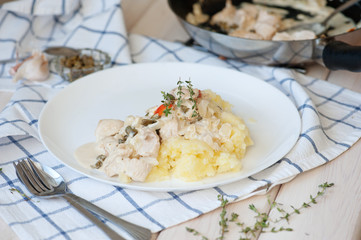 Chicken fillet in a creamy sauce with mashed potatoes and capers, thyme