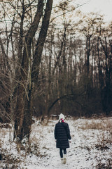 stylish hipster traveler girl with old photo camera exploring in snowy woods in winter. happy woman walking in cold forest. space for text. atmospheric moment. wanderlust