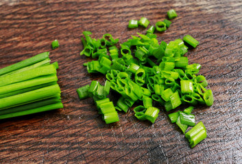 Chives on wooden background.