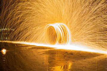 Spin fire show on the beach,Long exposure, art of fire show on the beach at night