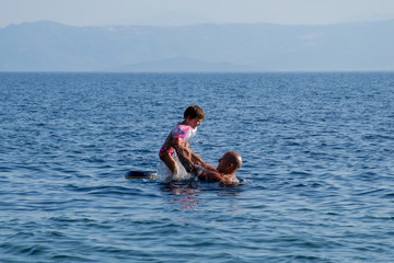 Dad and daughter are playing in the water