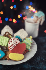 Fototapeta na wymiar Christmas cookies and cup of tea on dark color bokeh lights background