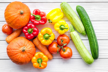 Base of healthy diet. Vegetables pumpkin, paprika, tomatoes, carrot, zucchini on white wooden background top view