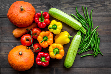 Base of healthy diet. Vegetables pumpkin, paprika, tomatoes, carrot, zucchini on dark wooden background top view