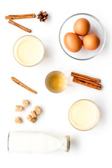Fototapeta na wymiar Ingredients for eggnog. Eggs, milk, cinnamon, whiskey on white background top view