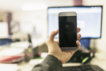Office worker with smartphone in hands, work distractions
