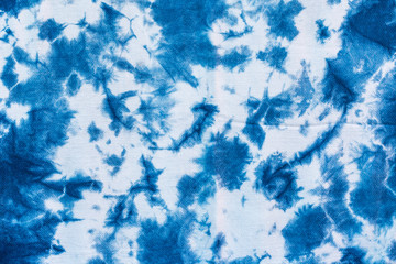 The fabric indigo tie dye as a background and texture. - obrazy, fototapety, plakaty