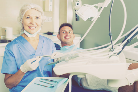 Female dentist with male patient in chair
