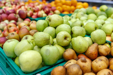 apples of different colors on display in a market