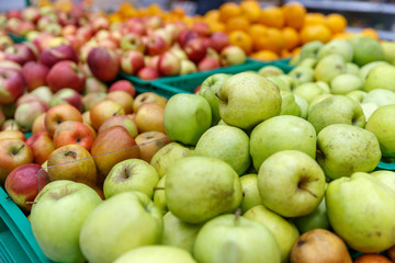 apples of different colors on display in a market