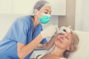 Senior woman getting facial injection