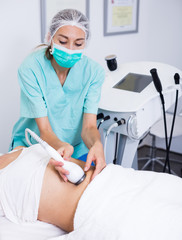 Female cosmetologist during procedure cryolipolyse