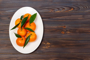 mandarins on a plate. Still life with tangerines on wooden table