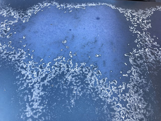 Close up of damages on the surface of an old blue car body made by weather conditions