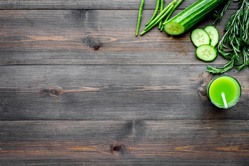 Green detox beverage with cucumber, asparagus, zucchini on dark wooden background top view copyspace