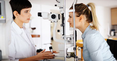 Naklejka premium Optometrist examining patient in modern ophthalmology clinic