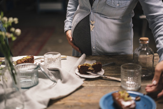 Pregnant woman with a colleague working on a food photoshoot in a studio