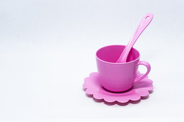 plastic, colored, children's cup with a spoon and saucer