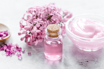 Fototapeta na wymiar organic salt, cream, extract in lilac cosmetic set with flowers 