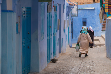 Obraz na płótnie Canvas Traditional moroccan courtyard in Chefchaouen blue city medina in Morocco, architectural details in Blue town Chaouen. Typical blue walls and colorful flower pots.