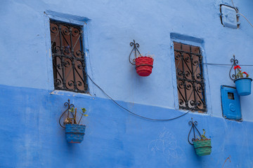 Traditional moroccan courtyard in Chefchaouen blue city medina in Morocco, architectural details in Blue town Chaouen. Typical blue walls and colorful flower pots.