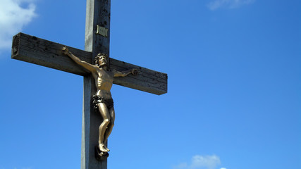 Fototapeta premium Cross with Jesus Christ on Lusen hill summit in Bayerischer Wald