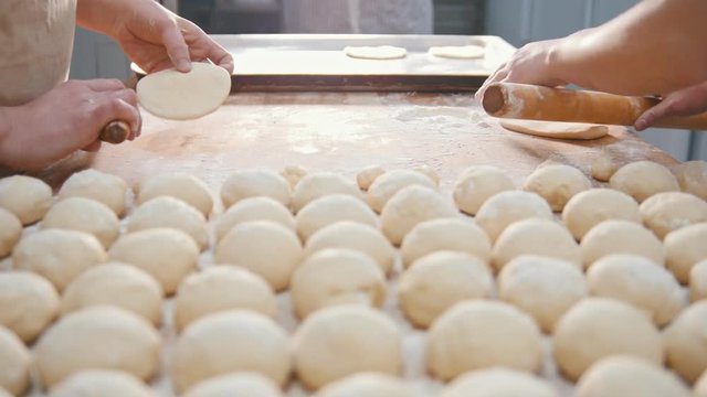 Cooks roll the dough for baking, raw dough on the Board
