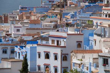 Traditional moroccan courtyard in Chefchaouen blue city medina in Morocco, architectural details in Blue town Chaouen. Typical blue walls and colorful flower pots.