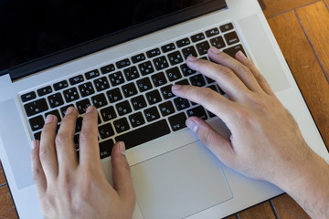 Man working at home office hand typing on keyboard close up