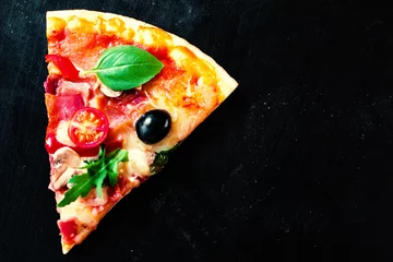 Photo sur Plexiglas Pizzeria Pizza jambon, tomate et fromage sur fond sombre. Pizza chaude avec saucisse pepperoni servie dans une pizzeria ou un restaurant
